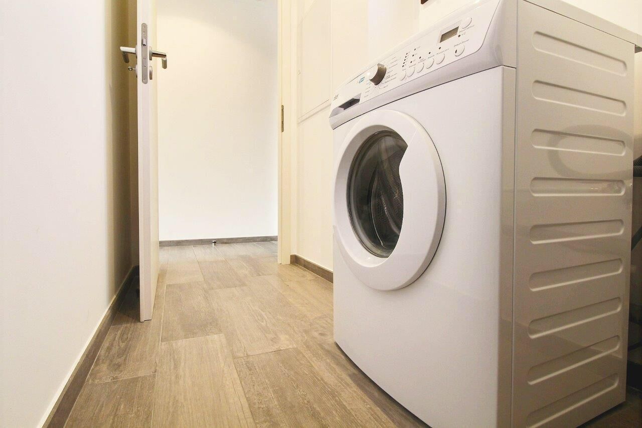 Ein moderner Waschraum mit einer Waschmaschine mit Frontlader und einem Trockner.