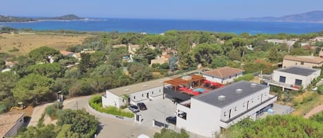 A residential area with a large building featuring a flat roof and a covered outdoor area.