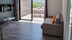 Una sala de estar moderna con un sofá, un televisor y un comedor.
