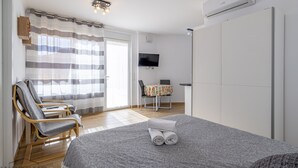Een slaapkamer met een bed, een stoel, een tafel en een televisie.