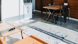 Eine moderne Küche mit einem weißen Kühlschrank, einem Holzespeisetisch und einer Couch.