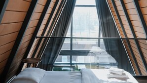 Ein Schlafzimmer mit Schräge und großem Fenster.