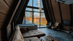 Ein stilvolles Loft-Zimmer mit großem Fenster, einer Couch, einem Couchtisch und einem Sessel.