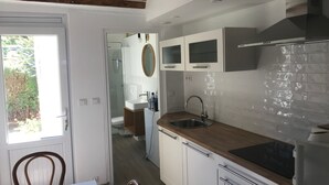 A modern kitchen with white cabinets, a wooden countertop, and a stainless steel sink. - House facing the sea 3* classification (Langrune-sur-Mer)