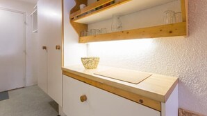 Una cocina con estantes de madera, tabla de cortar y un bol.