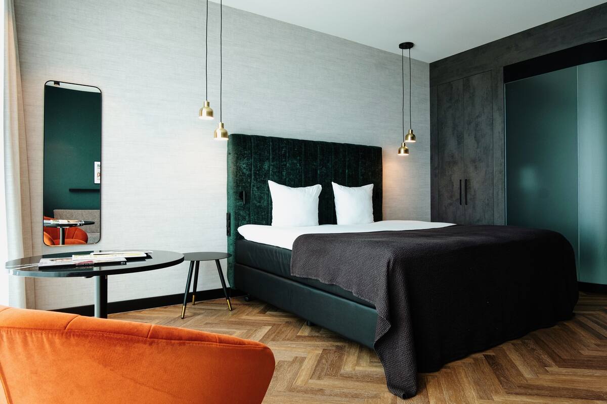 Une chambre d’hôtel moderne avec un grand lit, une table ronde et une chaise.