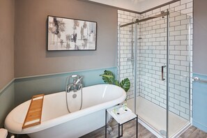 Bathtub, towels, shampoo, toilet paper