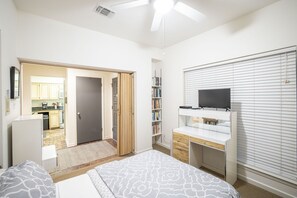 A bedroom with a bed, a desk, a television, and a wardrobe. - River Bend Cw C109 3 Bedroom Condo by RedAwning (New Braunfels)