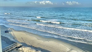 A beach with a clear sky, waves, and a distant moon. - Direct Luxury Ocean Front 
Includes umbrella - 2 chairs set up daily 5/31-9/5 (Murrells Inlet)