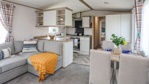 Um espaço compacto com cozinha compacta, área de refeições e sofá com manta.