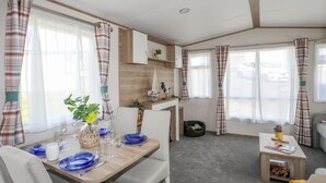 Um espaço compacto com área de refeições, kitchenette e zona de estar.