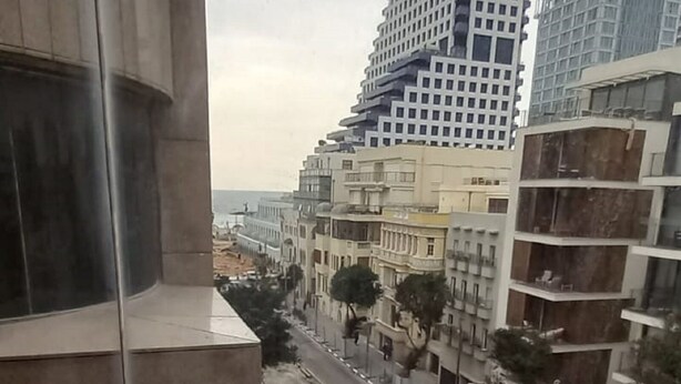 Vue depuis un immeuble de grande hauteur, avec un balcon incurvé donnant sur un paysage urbain.