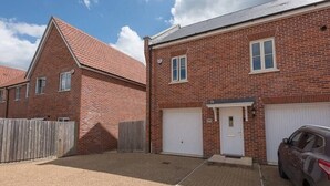 A residential area with two brick houses, one with a garage and another with a door. - 53 Bibby's Way, Framlingham (Woodbridge)