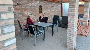 Un patio al aire libre con paredes de ladrillo, una mesa y sillas.