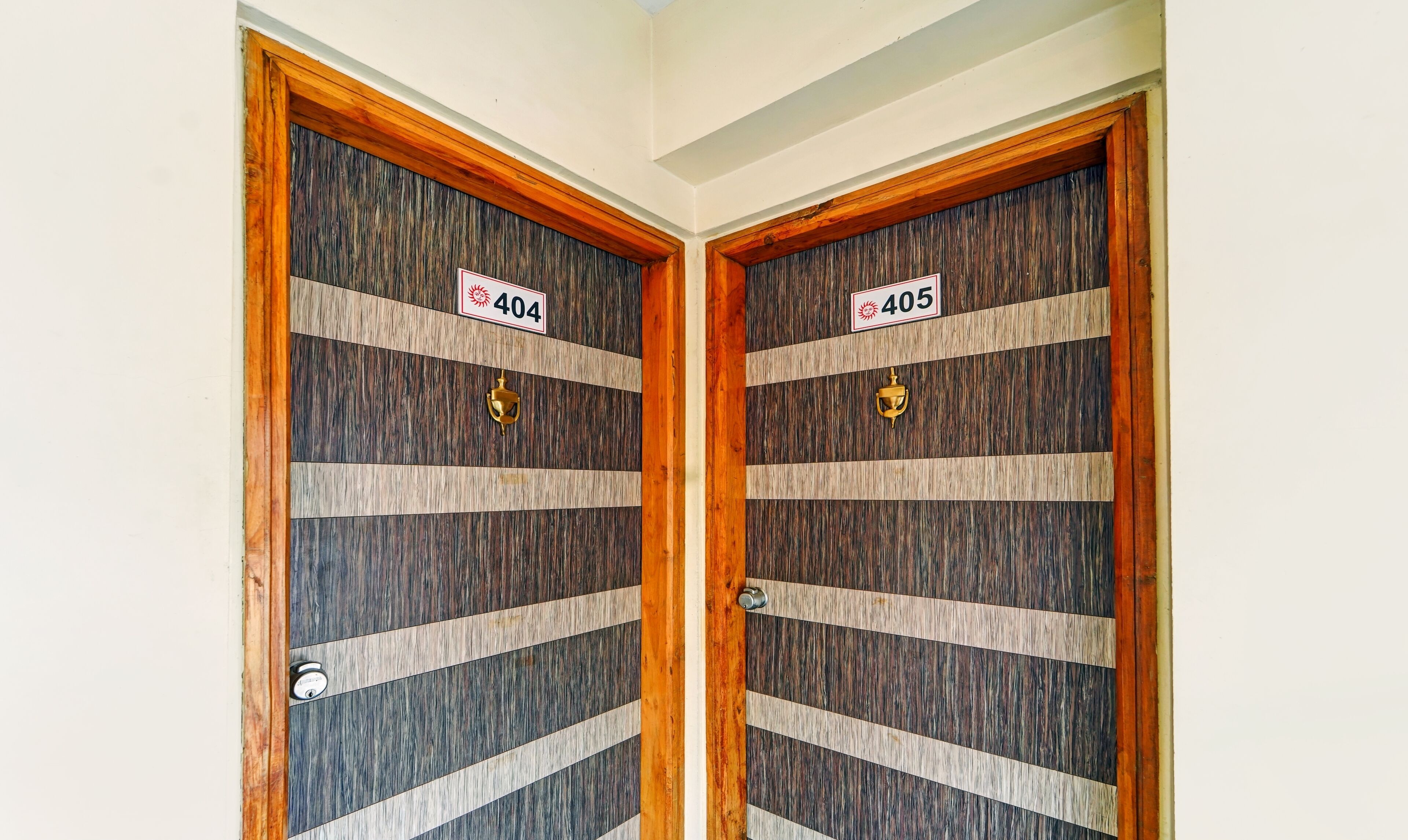 Two wooden doors with numbers 404 and 405, each with a brass handle and a keyhole.