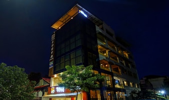Un hotel de varios pisos con un letrero destacado que dice 'Hotel Surya' y un cartel visible de restaurante.