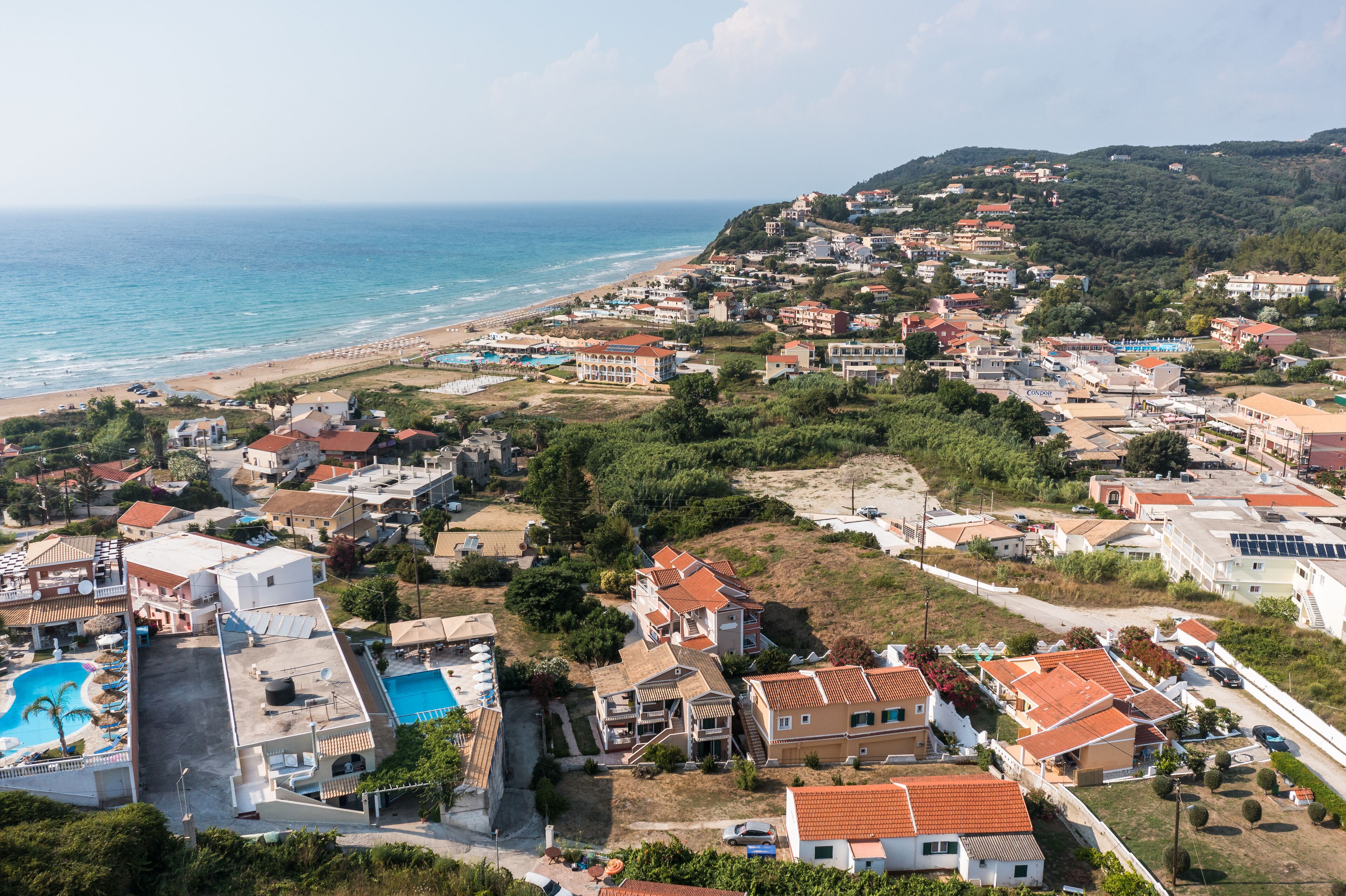 A coastal residential area with houses, a beach, and a swimming pool.
