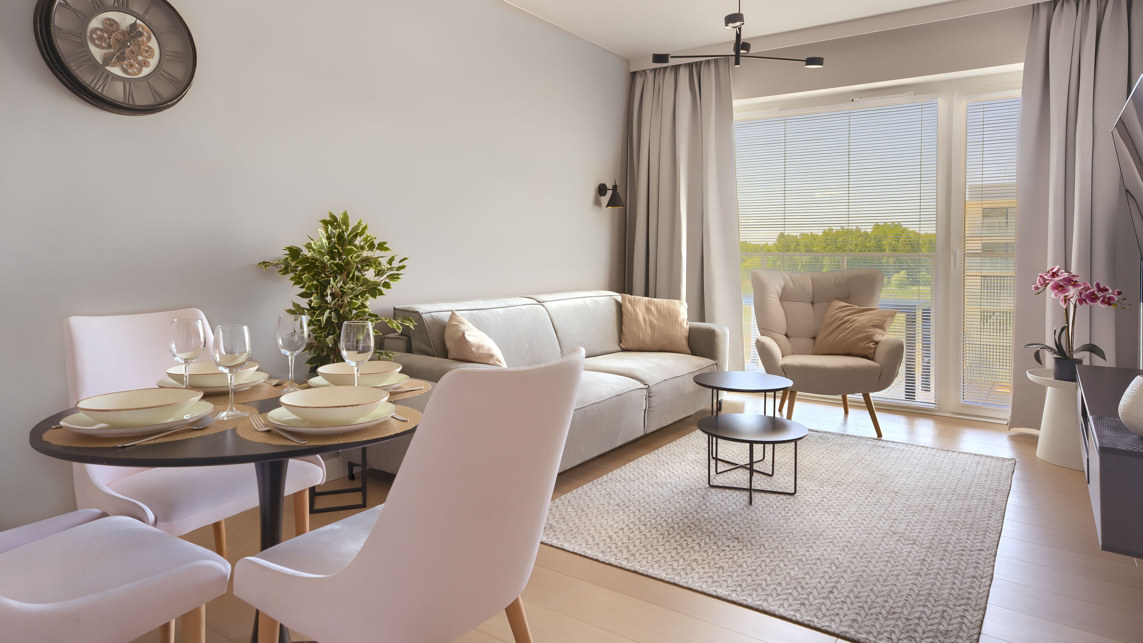 Una sala de estar moderna con comedor, un sofá, un sillón y una mesita.