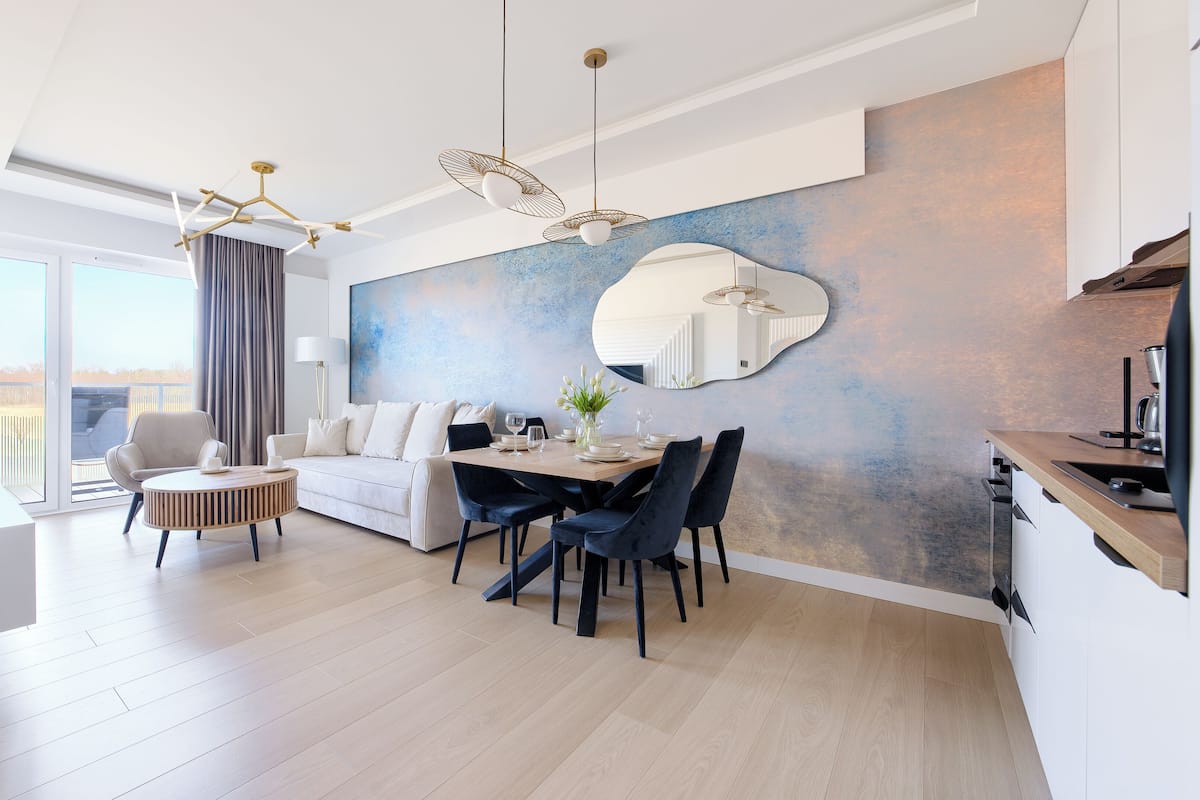 Un salón moderno con comedor, un ventanal y vistas al exterior.
