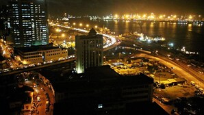 A nighttime cityscape with a prominent bridge, illuminated buildings, and a waterfront. - Immaculate 2-bed Apartment in Lekki Ajah (Lekki)