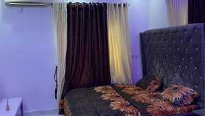 A bedroom with a tufted headboard, a patterned bedspread, and a modern ceiling design. - Immaculate 2-bed Apartment in Lekki Ajah (Lekki)