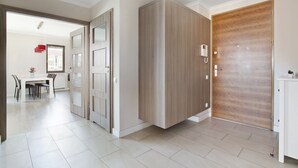 A modern interior with a dining area, a wardrobe, and a wooden door. - Elite Apartments Szafarnia King Size (Gdansk)