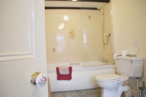 A bathroom with a toilet, bathtub, and shower. - Keepers (Alston)