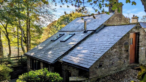 A stone building with a sloped roof, skylights, and a wooden door labeled "The Bottery." - Bothy (Alston)