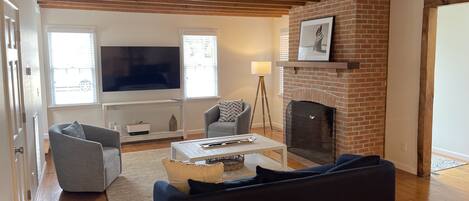 A living room with a fireplace, a television, and a sofa.