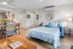 Une chambre à coucher avec un lit, un bureau, des chaises, une table et une lampe.