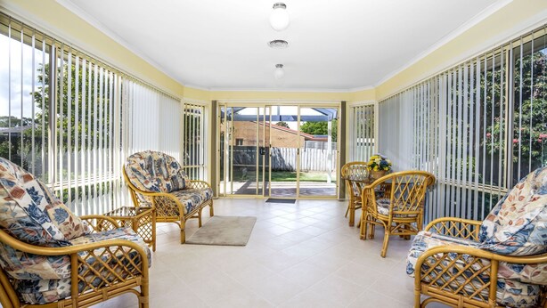 A sunlit room with wicker furniture, large windows, and a view of the outdoors. - Alkira Inverloch Holiday (Inverloch)