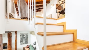 Una escalera con escalones de madera y una pared blanca.