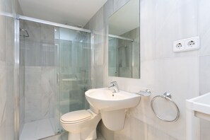 Regadera, secadora de cabello, toallas, papel de baño 