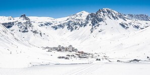 A snow-covered mountain landscape with a town nestled at its base. - 10m from resort center, 1st floor, tv, ski locker, 86m², Tignes (Tignes)