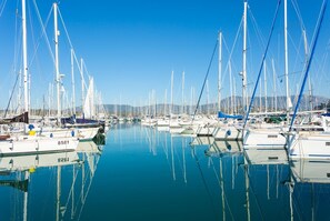Enjoy serene views of sailboats docked in the marina, surrounded by a picturesque landscape.
