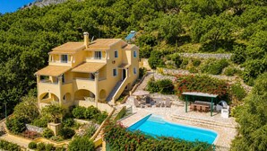 Un bâtiment à deux étages doté d’une piscine, d’un espace extérieur aménagé et d’un jardin.
