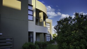 Un bâtiment moderne doté d’une façade incurvée, de grandes fenêtres et d’un balcon.