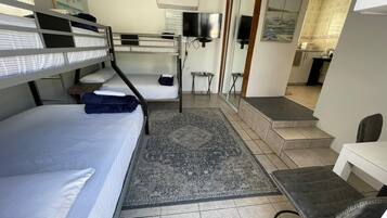 Tabla de planchar con plancha y ropa de cama