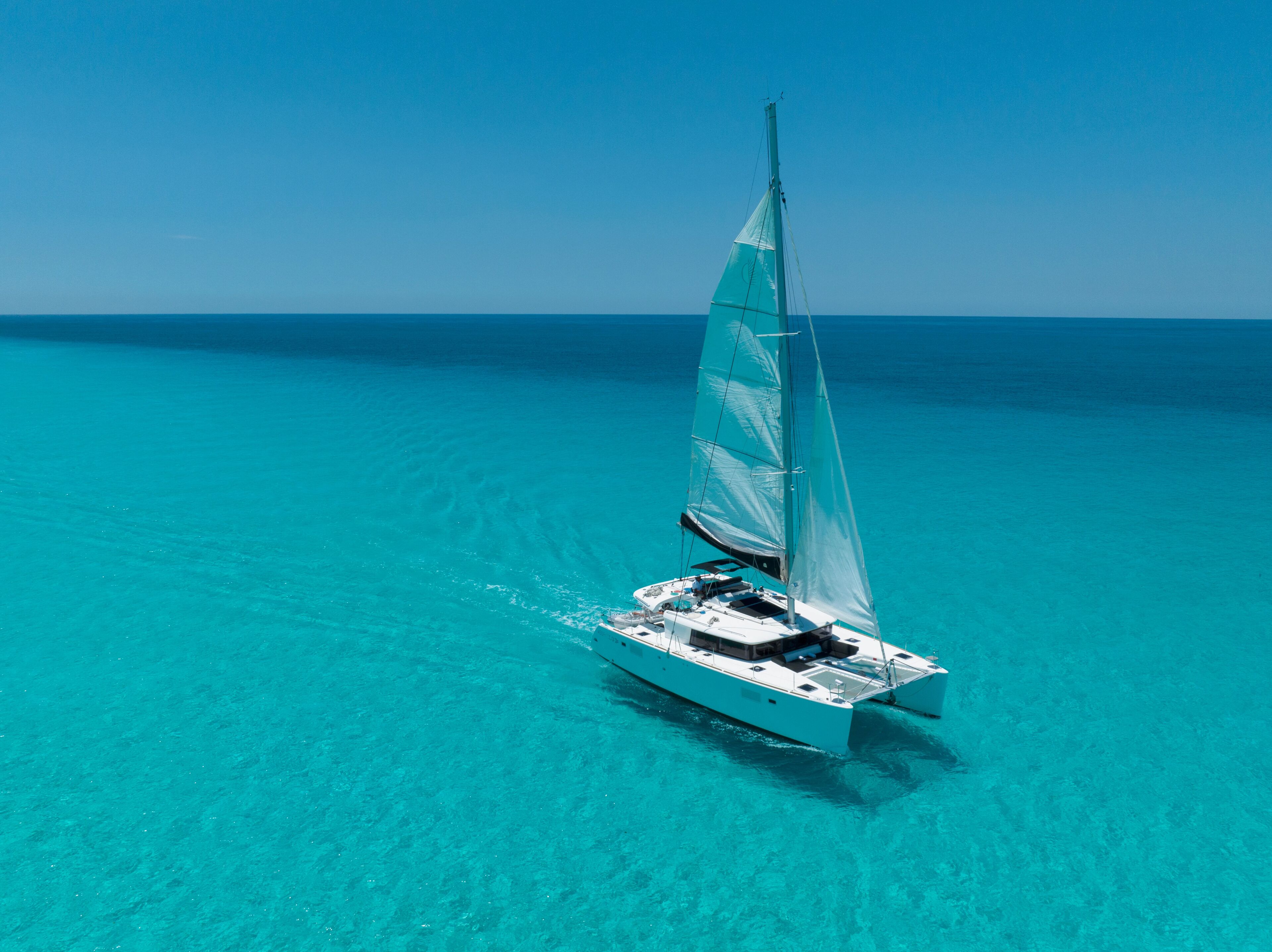 A sailboat on turquoise waters.