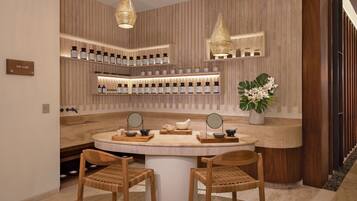 A spa lab with wooden panel walls, shelves with bottles, a round table with chairs, and two hanging lamps.