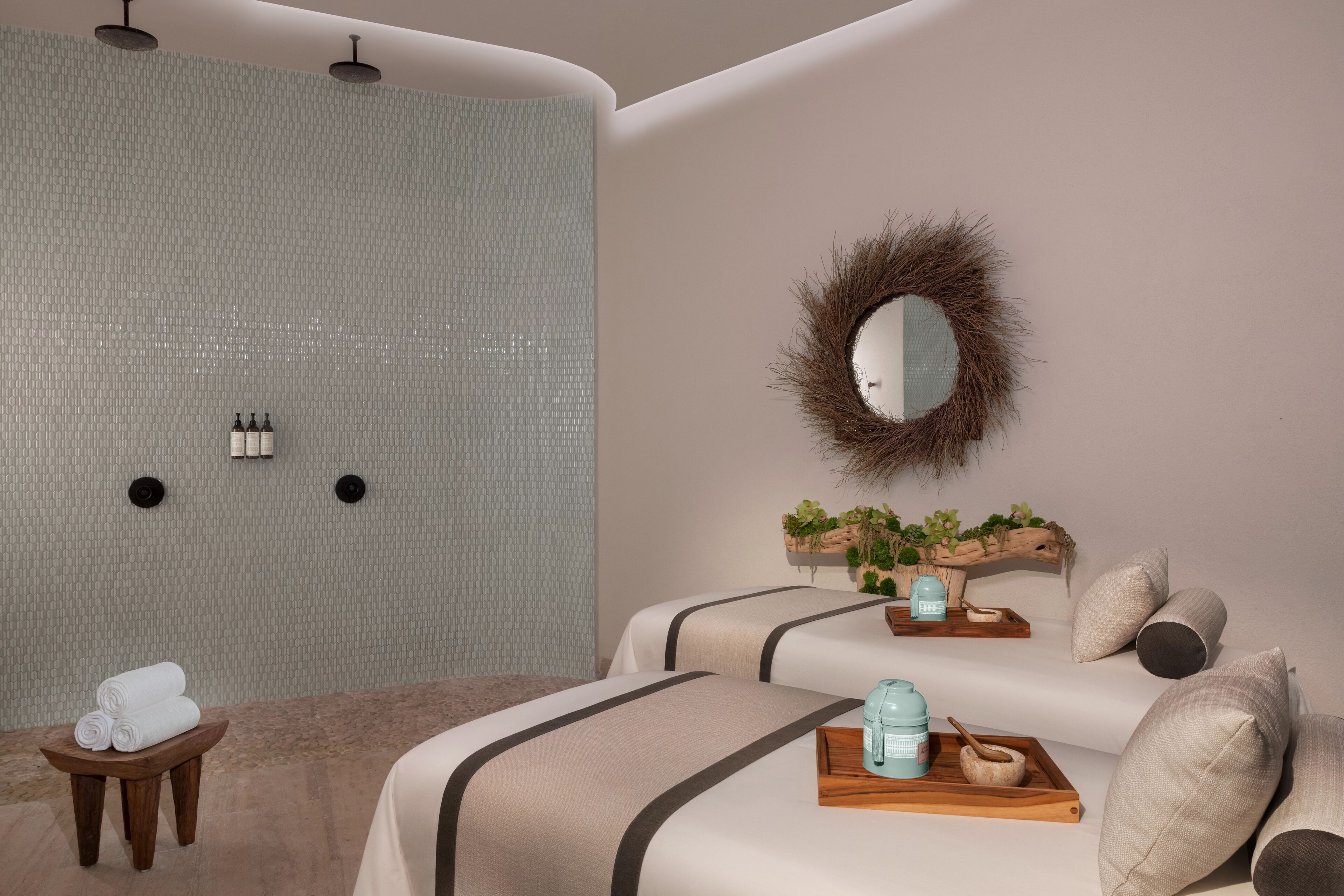 A modern bedroom with a large mirror, a wooden side table, and a bed with a headboard.