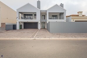 A modern two-story house with a garage, a balcony, and a gated driveway. - Dalton's, Langebaan 10-sleeper (Langebaan)