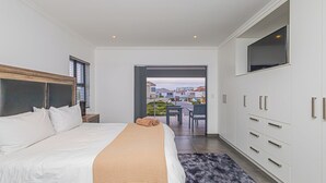 Quarto moderno com uma cama grande, um guarda-roupa e vista para o pátio exterior.
