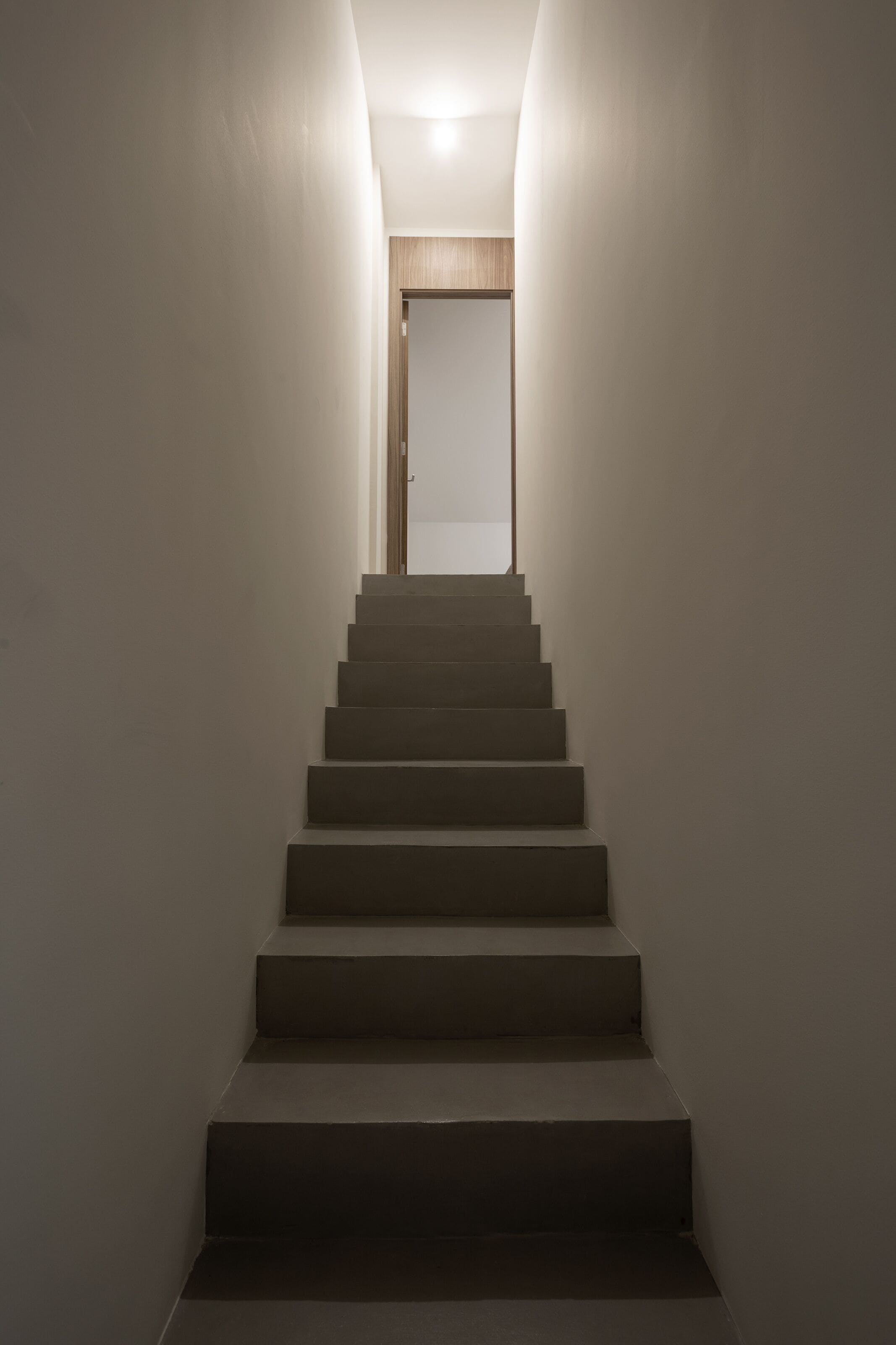 Eine modern gestaltete Treppe, die zu einer Tür führt.