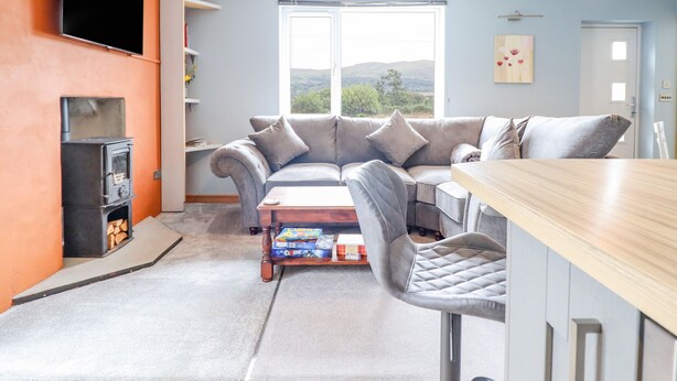 Un salon moderne avec un canapé, une table basse et un téléviseur fixé au mur.