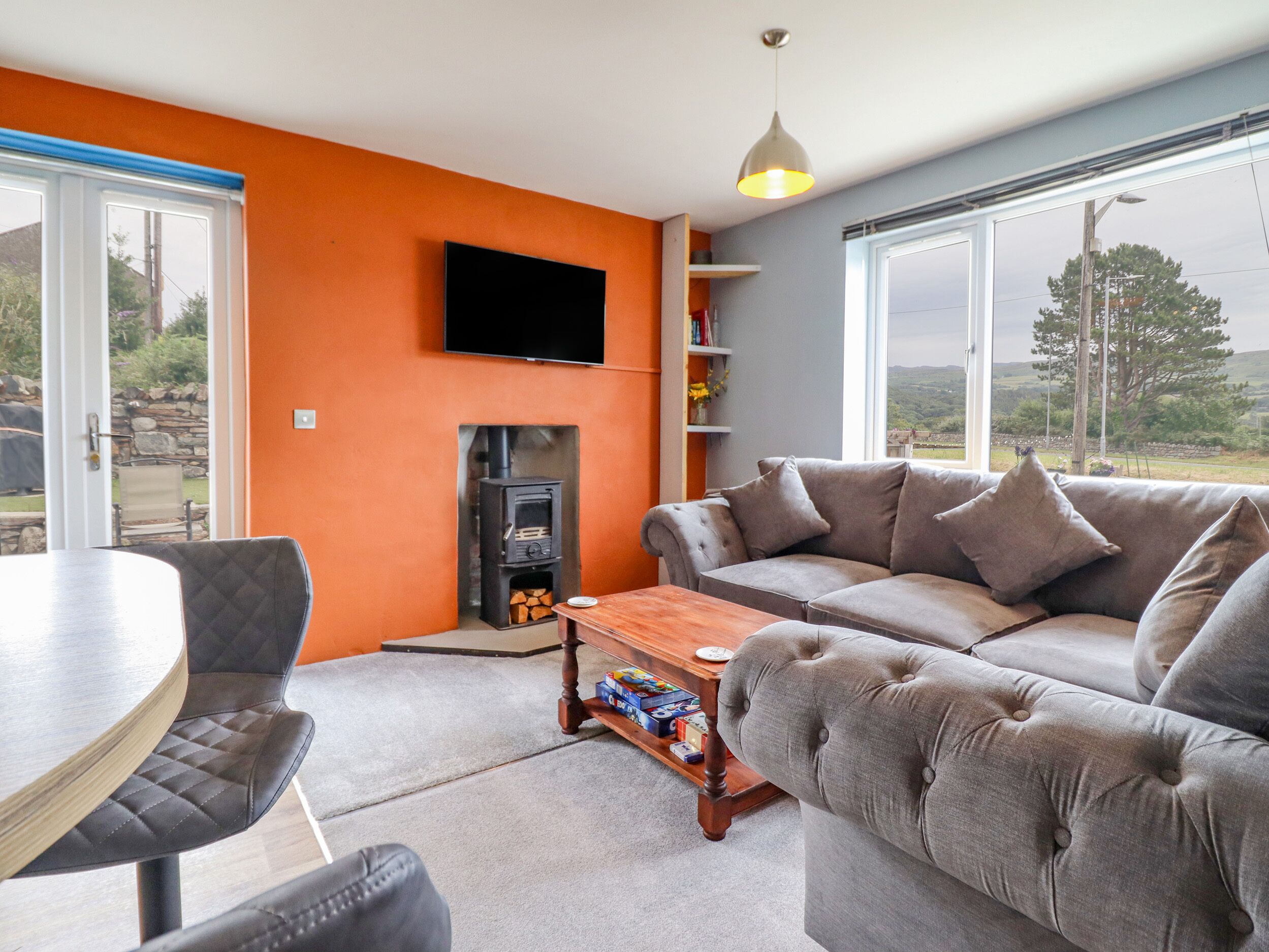 Una sala de estar con chimenea, sofá y una mesa.