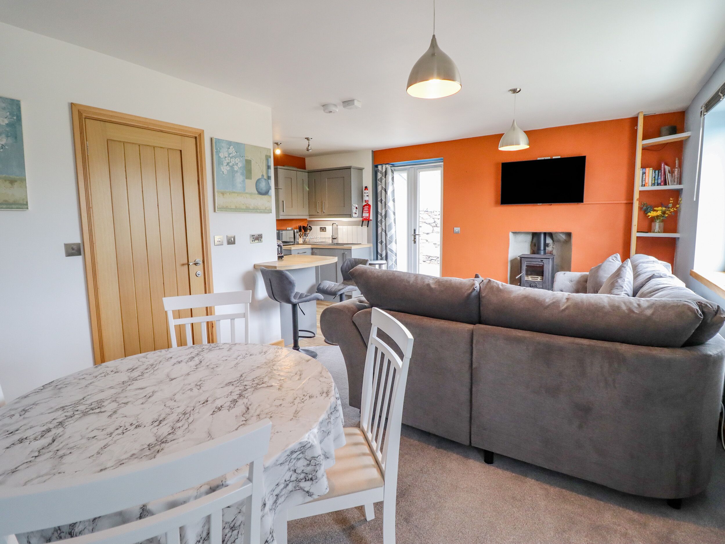 A modern living space with a kitchen, dining area, and a sofa.