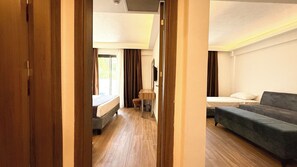 A hotel room with a wooden floor, a bed, a sofa, and a small table. -  Çınar Butik Hotel Bodrum (Bodrum)