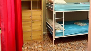 A small, single-bedded room with a wardrobe, a red curtain, and patterned floor tiles. - Cathedral Malaga Hostal - Hostel (Málaga)