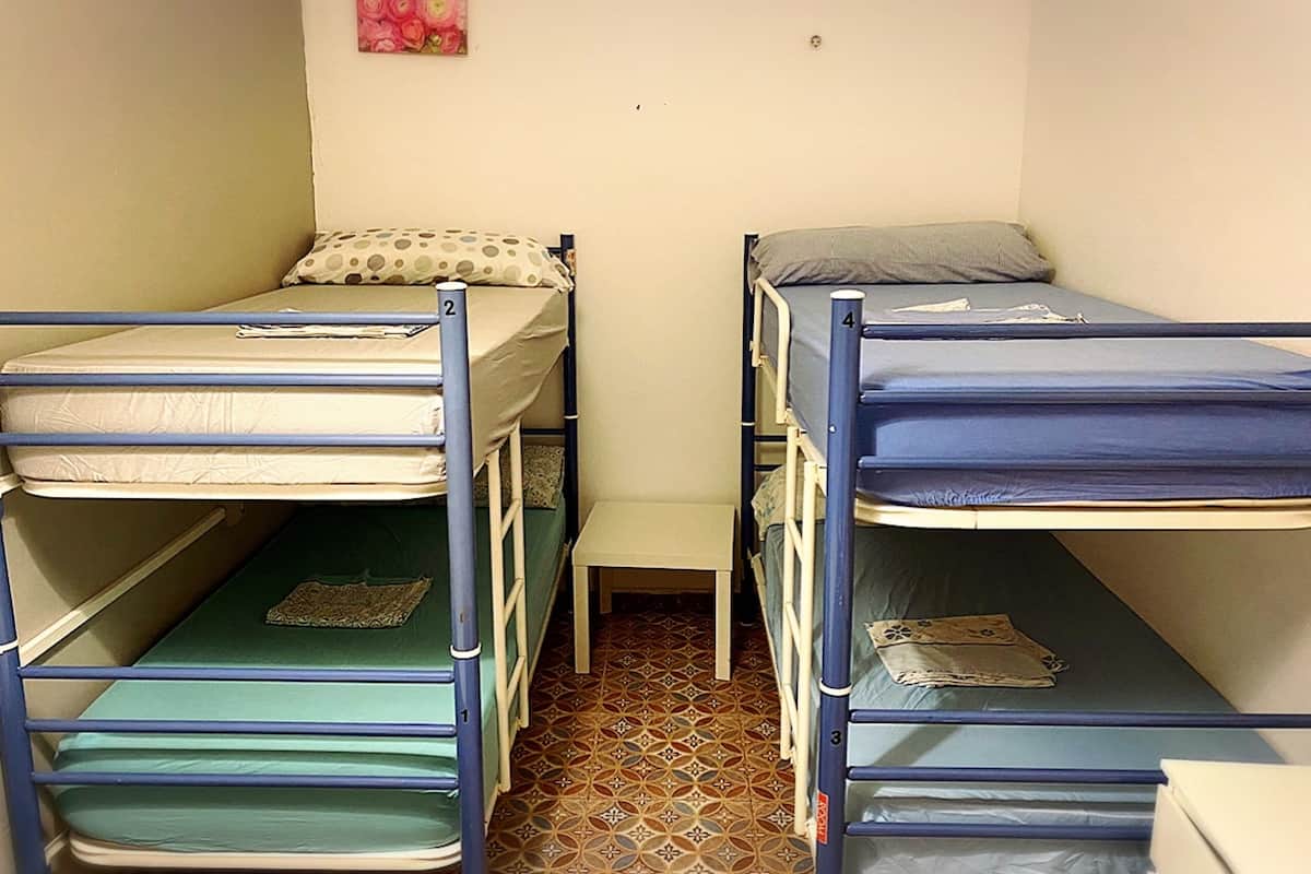 Un dormitorio con literas, una mesita pequeña y un cuadro colgado en la pared.